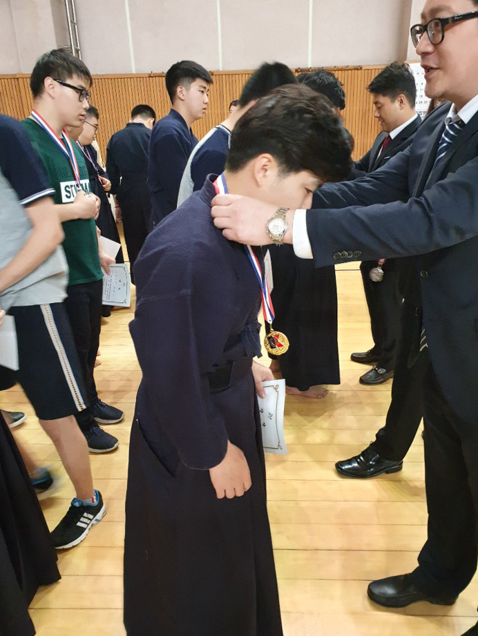 선수에게 금메달을 목에 걸어주고있는 모습
